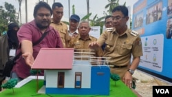 Bupati Sigi Irwan Lapata (berkacamata), mengamati miniatur hunian tetap (huntap) tipe 36 yang akan dibangun sebanyak 500 unit, bantuan dari Habitat Humanity Indonesia. (2/12/2019) Foto : Yoanes Litha