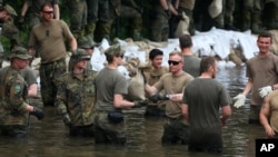 German Bundeswehr soldiers and other helpers pile sandbags in Rothensee, a suburb of Magdeburg, at river Elbe, eastern Germany, June 9, 2013.