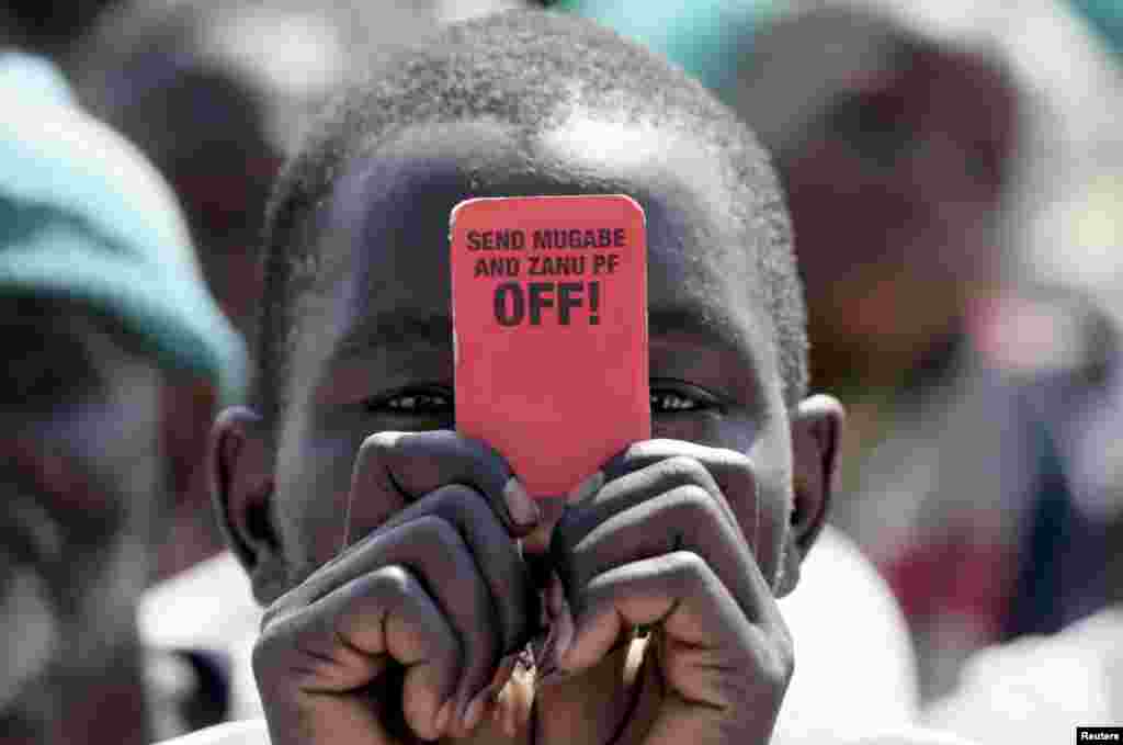 A Zimbabwe opposition Movement for Democratic Change (MDC) supporter holds a party slogan card at a rally to celebrate the ninth anniversary of his Movement for Democratic Change (MDC) party in Gweru, September 7, 2008. Tsvangirai said on Sunday his party would rather quit power-sharing talks than sign an unsatisfactory deal and challenged President Robert Mugabe to call a new election.