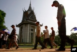 FILE - Foreign tourists walk through Choeung Ek stupa, which stores thousands of human bones and skulls of the Khmer Rouge's victims in the outskirt of Phnom Penh, Cambodia, June 25, 2011.