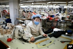 FILE - North Korean workers sew items at a factory of a South Korean-owned company at the jointly-run Kaesong Industrial Complex, in Kaesong, North Korea, Dec. 19, 2013.