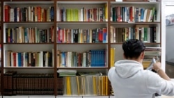 A prisoner takes a book from the library at Avlona's prison school, north of Athens, Greece, February 10, 2021. (AP Photo/Thanassis Stavrakis)