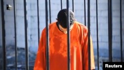 A man purported to be Islamic State captive Jordanian pilot Muath al-Kasaesbeh is seen standing in a cage in this still image from an undated video filmed at an undisclosed location made available on social media on Feb. 3, 2015.