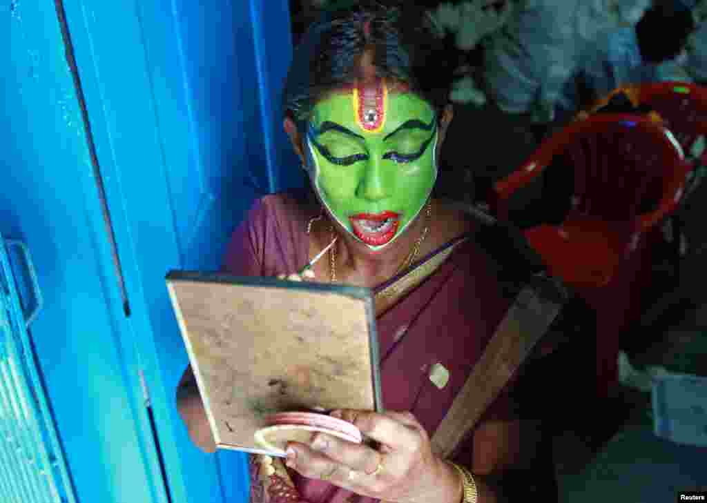 A performer gets ready backstage before taking part in the annual eight-day long Vrischikolsavam festival, which features a colorful procession of decorated elephants along with drum concerts, at Sree Poornathrayeesa temple in Kochi, India.