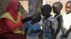 A social worker gives polio drops to children from al-Muniera village in Madani, FILE November 18, 2007. 