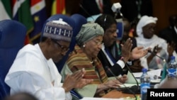 Le président nigérian Muhammadu Buhari, à gauchede la présidente du Libéria, Ellen Johnson Sirleaf, et Marcel de Souza, président de la Commission de la CEDEAO, assistent à la session ordinaire des chefs d'État et de gouvernement de la CEDEAO à Abuja, au Nigeria, le 17 décembre 2016