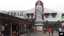 Police investigators arrive at the Ekayana Grha Buddhist temple where a bomb went off on Sunday night, in Jakarta, Indonesia, August 5, 2014. 