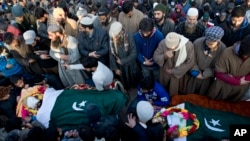 Kashmiri villagers offer joint funeral prayers for a civilian Abid Lone, right, and local rebel Adnan Ahmed in Pulwama, south of Srinagar, Indian controlled Kashmir, Dec. 15, 2018. 