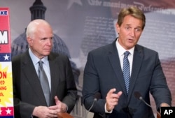 FILE- Arizona Senators John McCain, left, and Jeff Flake talk to reporters on Capitol Hill in Washington, Nov. 4, 2015.