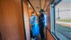 Medical personnel brief people waiting to receive COVID-19 vaccinations at the Swartkops railroad yard outside Gqeberha, South Africa, Sept. 23, 2021. South Africa has sent a train carrying COVID-19 vaccines into one of its poorest provinces.