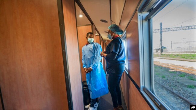 Medical personnel brief people waiting to receive COVID-19 vaccinations at the Swartkops railroad yard outside Gqeberha, South Africa, Sept. 23, 2021. South Africa has sent a train carrying COVID-19 vaccines into one of its poorest provinces.
