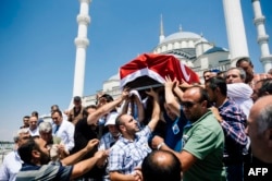 People carry the coffin of victim of the coup attempt Sehidmiz Murat Inci during his funeral ceremony at the Kocatepe Mosque in Ankara on July 18, 2016.