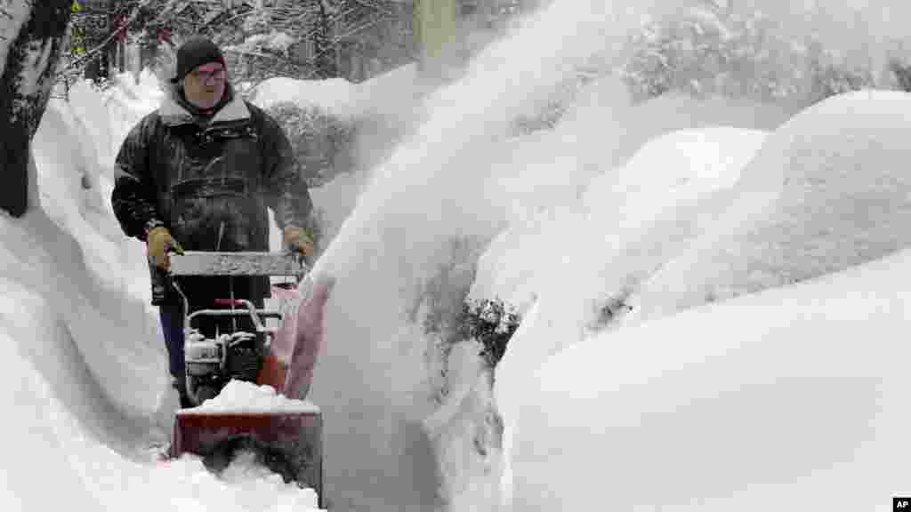 Un homme enlève la neige le dimanche 15 février 2015, à Concord, NH. Une tempête a apporté un nouveau cycle de vent fouettée neige en Nouvelle-Angleterre dimanche, créant des conditions proches du voile blanc dans les zones côtières.