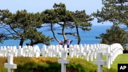 Visitors walk among graves at the Colleville American military cemetery, in Colleville-sur-Mer, western France, on the 71th anniversary of the D-Day landing, June 6, 2015. 