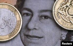 A two Euro coin is pictured next to a one Pound coin on top of a portrait of Britain's Queen Elizabeth. (Reuters)