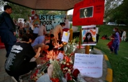 "Seorang aktivis hak-hak perempuan meletakkan lilin di samping poster bergambar Noor Mukadam, yang baru-baru ini dipenggal, untuk memberi penghormatan kepada Noor dan korban kekerasan dalam rumah tangga lainnya, di Islamabad, Pakistan. (Foto: AP)