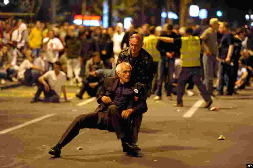 May 29: A man helps a supporter during a protest by the Serbian Radical Party against the arrest of general Ratko Mladic in Belgrade. (Reuters)