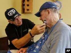 FILE -- In this Nov. 27, 2013 photo, caregiver Warren Manchess, 74, left, shaves Paul Gregoline, 92, in Noblesville, Indiana. (AP Photo/Darron Cummings)