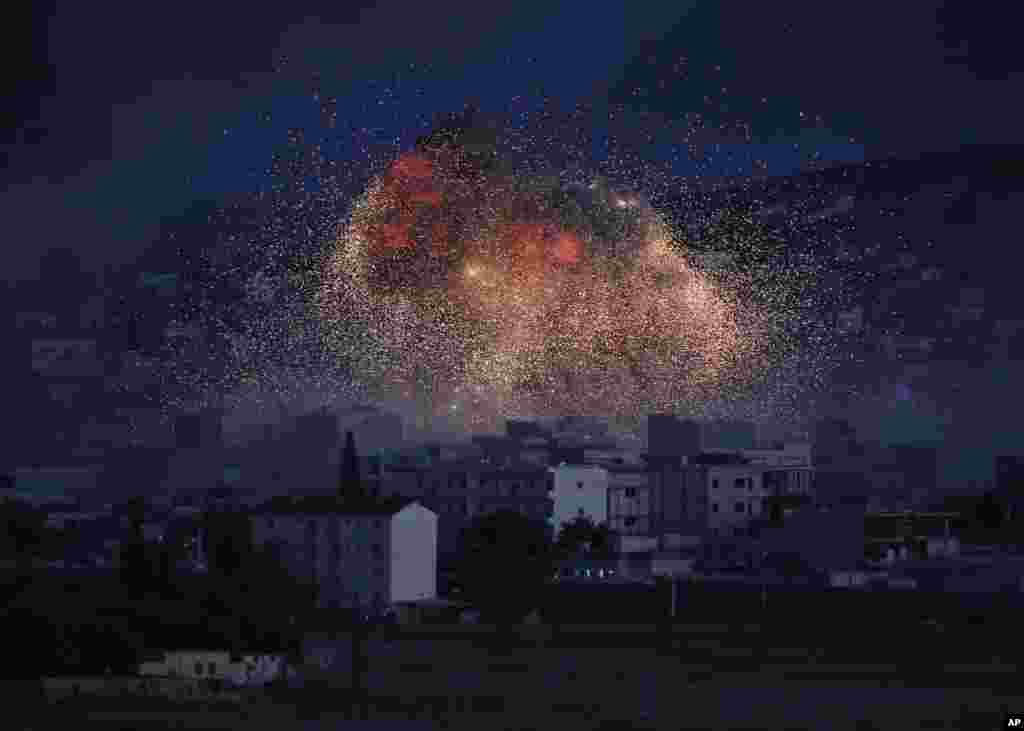 Cuộn khói dày đặc và đám lửa bùng lên từ một cuộc không kích của liên minh do Mỹ dẫn đầu ở thị trấn Kobani, Syria, khi nhìn từ một đỉnh đồi ở ngoại ô Suruc, tại biên giới Thổ Nhĩ Kỳ-Syria. 
