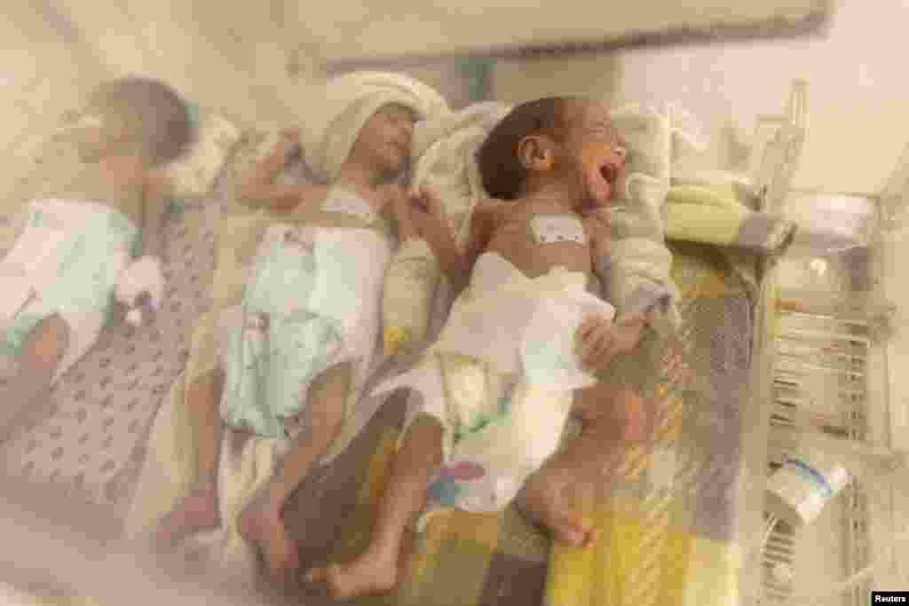 Three babies share an incubator at the premature infants ward at the Indira Gandhi hospital in Kabul, Afghanistan, Oct. 24, 2021.