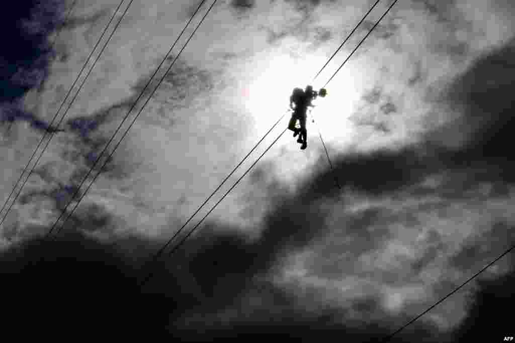 A technician works on an electricity transmission tower on the outskirts of Yangon, Myanmar.