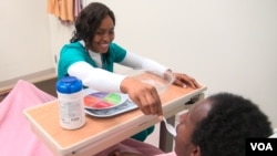 A nurse aid trainee practices feeding a classmate at the Carlos Rosario International Public Charter School in Washington, D.C.