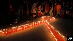 FILE - Nepalese women and children light candles on the eve of World AIDS Day in Kathmandu, Nepal, Nov. 30, 2015. 