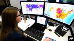 Whitney Flynn, a physical scientist at the National Water Center in Tuscaloosa, Ala., works on computer screens showing flood predictions and other information on March 21, 2019. 