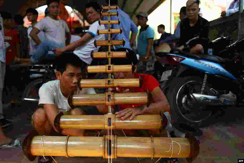 Vietnamese men prepare their traditional flute-kites before taking a part in a centuries-old flute kites festival at Ba Duong Noi village in Hanoi.