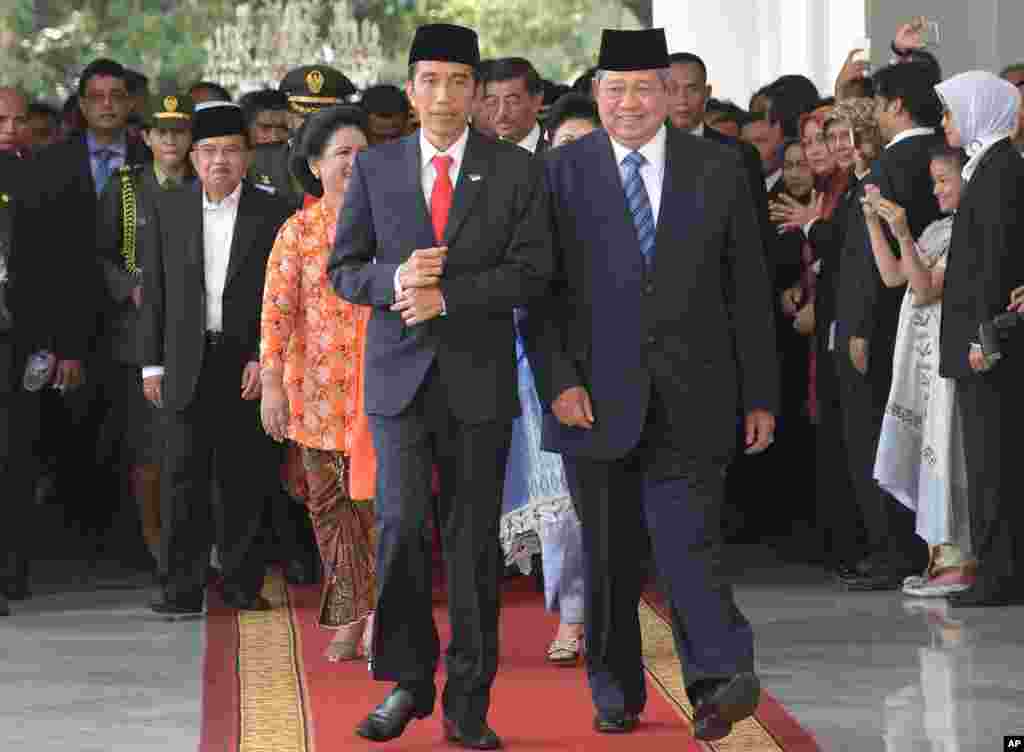 Indonesia's President Joko Widodo, left, walks with his predecessor Susilo Bambang Yudhoyono at the presidential palace in Jakarta, Indonesia, Oct. 20, 2014.