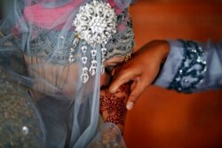 Seorang perempuan mencium tangan suaminya setelah akad nikah di sebuah masjid di Banda Aceh, 9 Desember 2012. (Foto: Reuters)