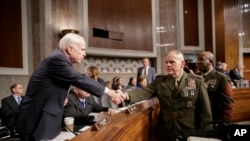 Senate Armed Services Committee Chairman Sen. John McCain, R-Ariz., left, welcomes Marine Corps Commandant Gen. Robert B. Neller, center, and Sgt. Major of the Marine Corps Ronald L. Green on Capitol Hill in Washington, Tuesday, March, 14, 2017, prior to the start of the committee's hearing on the investigation of nude photographs of female Marines and other women that were shared on the Facebook page "Marines United."