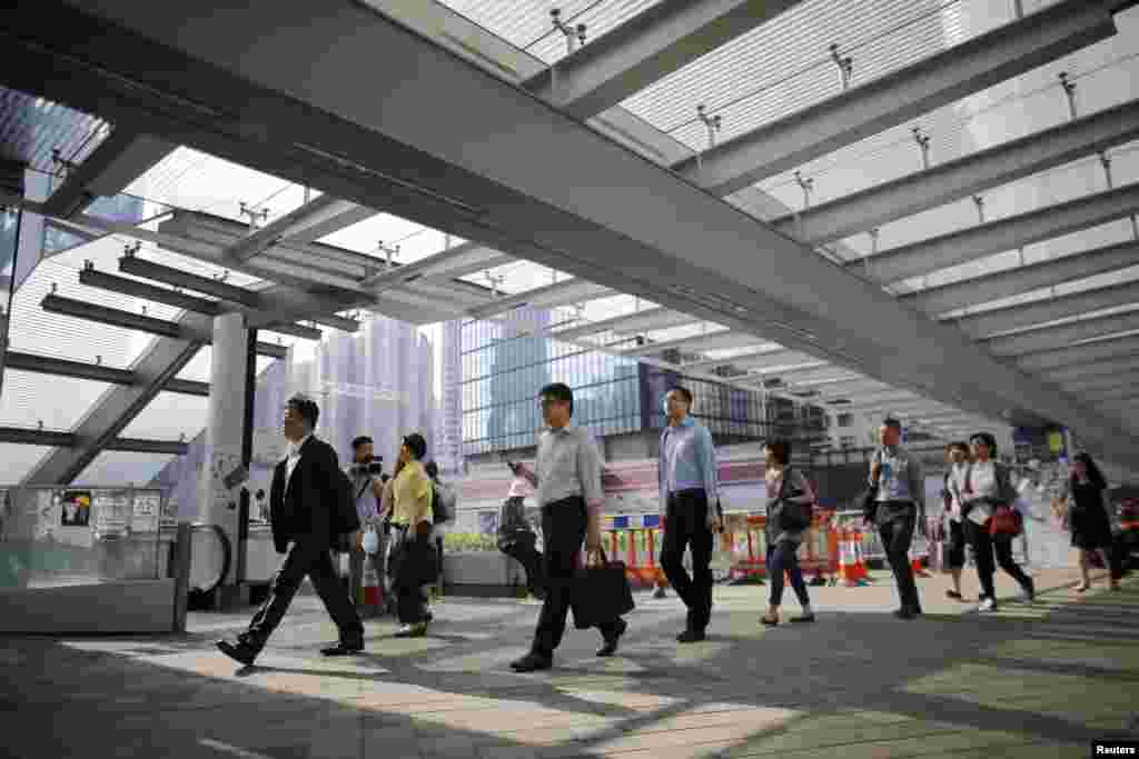 Government employees arrive to work at an area occupied by protesters outside of the government headquarters building in Hong Kong, Oct. 6, 2014.