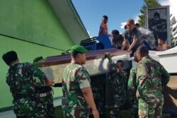 Para pekerja menyiapkan peti jenazah untuk para pekerja konstruksi yang diduga ditembak mati, di Wamena, Jakarta, (Foto: AFP)