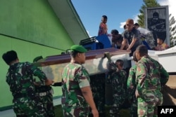 Para pekerja menyiapkan peti jenazah untuk para pekerja konstruksi yang diduga ditembak mati, di Wamena, Jakarta, (Foto: AFP)