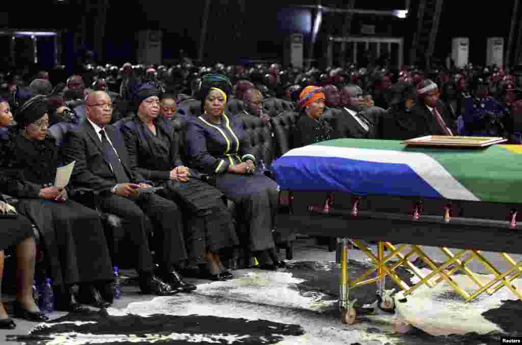 Presiden Afrika Selatan Jacob Zuma (kedua kiri), mantan istri mantan presiden Afrika Selatan Nelson Mandela, Winnie Mandela (kiri), dan janda Mandela, Graca Machel (ketiga kiri), duduk dekat peti mati Mandela pada upacara pemakaman di Qunu, Afrika Selatan,&nbsp; 15 Desember 2013.