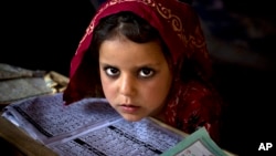 An internally displaced Pakistani girl from a tribal area attends her daily lesson at a madrassa, a school for the study of Islam, on the outskirts of Islamabad, Pakistan, Monday, April 6, 2015.