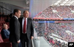 El presidente ruso, Vladimir Putin, (derecha) y el primer ministro ruso, Dmitry Medvedev, observan el partido entre Rusia y Arabia Saudita que dio inicio al Mundial Rusia 2018 en Moscú, el 14 de junio de 2018.