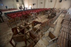 FILE - Chairs are scattered and blood stains the floor at the Army Public School auditorium a day after Pakistani Taliban gunmen stormed the school killing 150 people, in Peshawar, Pakistan, Dec. 17, 2014.