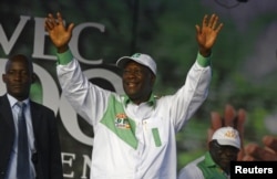 Ivory Coast's President Alassane Ouattara of the Rally of the Houphouetists for Democracy and Peace (RHDP) party waves as he arrives for a campaign rally at the place inch alla in Abidjan, Oct. 20, 2015.