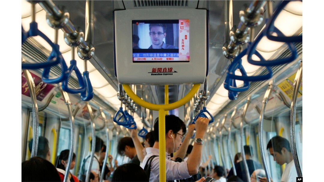 A TV screen shows the news of Edward Snowden, a former CIA employee who leaked top-secret documents about sweeping U.S. surveillance programs, in the underground train in Hong Kong Sunday, June 16, 2013.