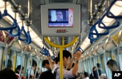 A TV screen shows the news of Edward Snowden, a former CIA employee who leaked top-secret documents about sweeping U.S. surveillance programs, in the underground train in Hong Kong Sunday, June 16, 2013.