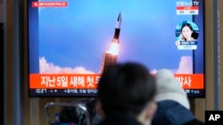 韩国民众在首尔一个火车站观看电视播放的朝鲜试射导弹新闻画面。（2022年1月27日）