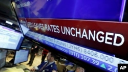 A television screen on the floor of the New York Stock Exchange shows the rate decision by the Federal Reserve, Jan. 27, 2016. 
