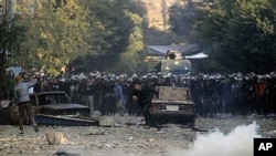 Protester runs for cover during clashes with Egyptian riot police, Cairo, Nov. 21, 2011.