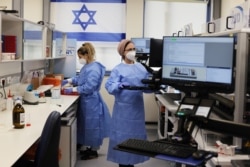 Technicians work at Healthcare Maintenance Organization (HMO) Maccabi's coronavirus disease (COVID-19) public laboratory, performing diverse and numerous tests, in Rehovot, Israel February 9, 2021. (REUTERS/Ammar Awad)