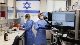 Technicians work at Healthcare Maintenance Organization (HMO) Maccabi's coronavirus disease (COVID-19) public laboratory, performing diverse and numerous tests, in Rehovot, Israel February 9, 2021. (REUTERS/Ammar Awad)