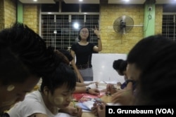 Han Zin Tun teaches English to teashop workers at night.