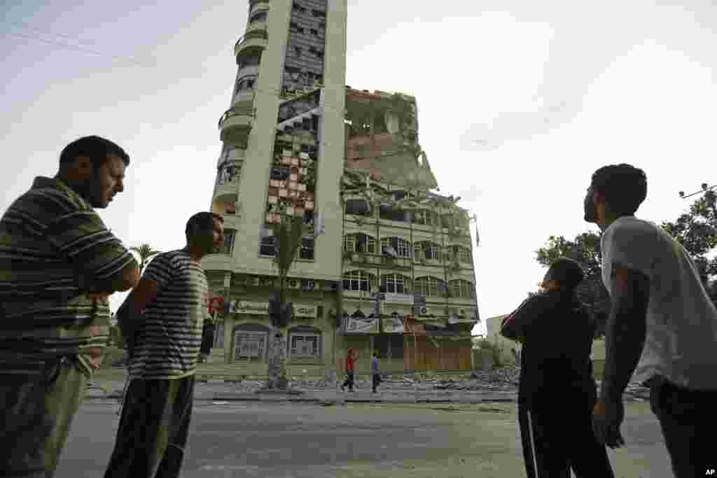 Palestinians inspect the damage of the Al-Shalam (Peace) tower, destroyed by an overnight Israeli strike, in Gaza City, July 22, 2014.&nbsp;