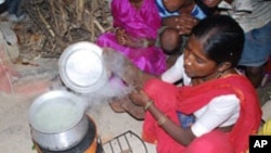 A woman in India is uses a cookstove that produces less smoke for burning wood or any other fuel.
